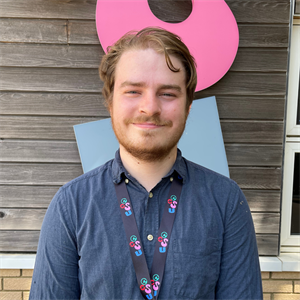 White person with short wavy light brown hair and beard smiling at the camera