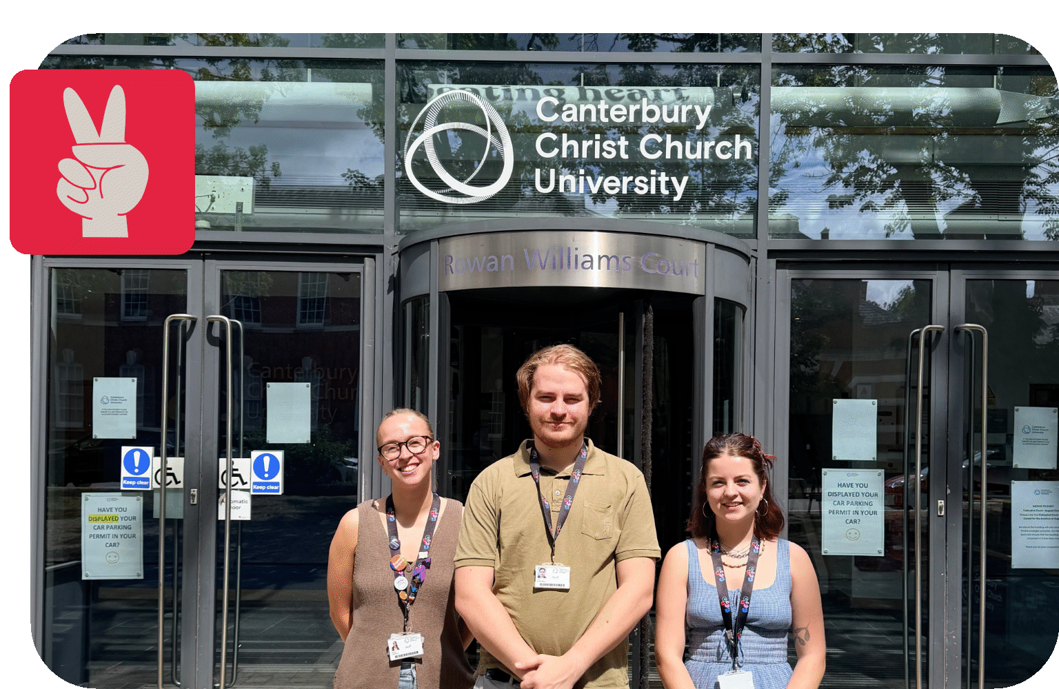 Three people stood in front of a university building with a sign that reads Canterbury Christ Church University